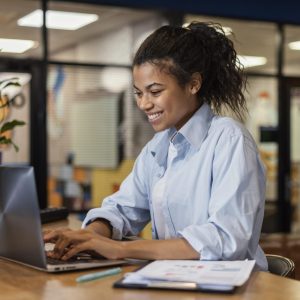 side-view-smiley-woman-working-with-laptop-office